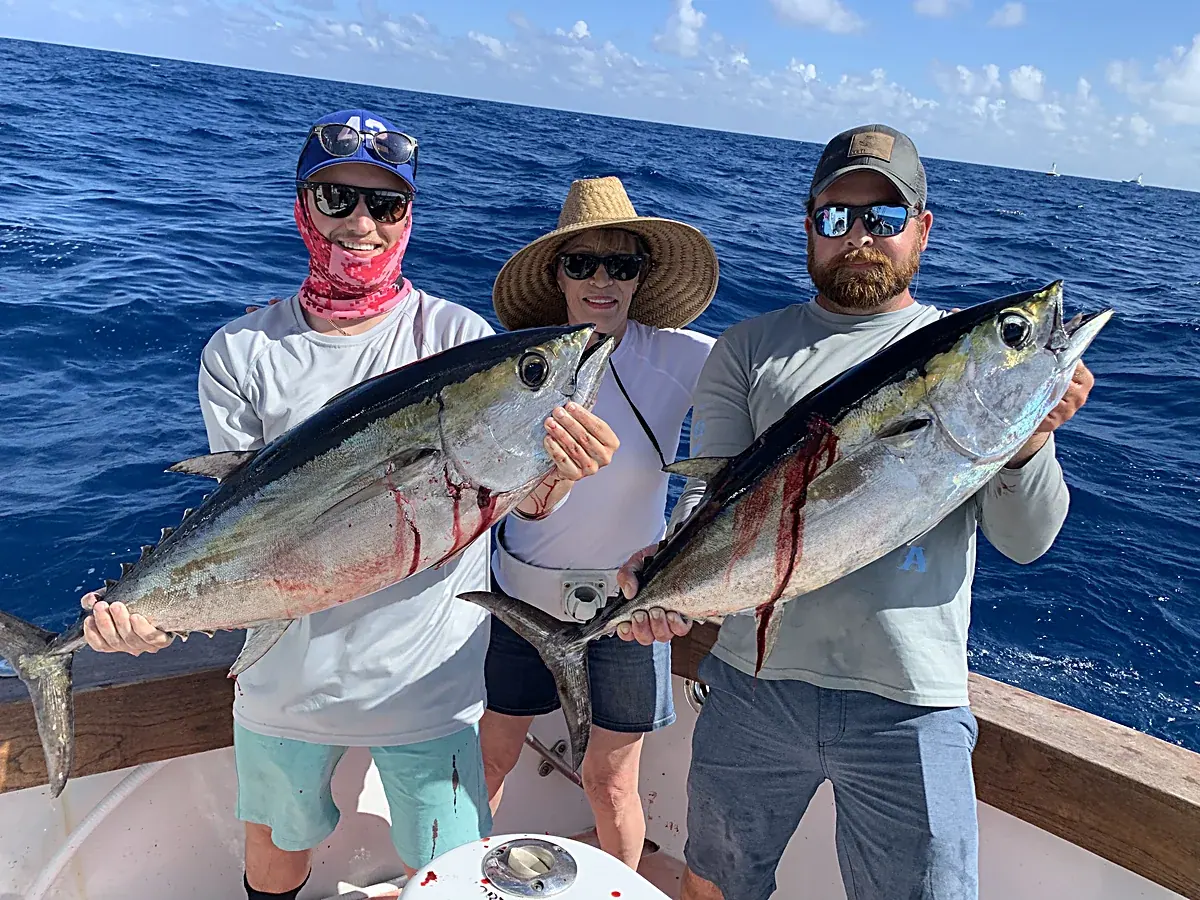Two anglers holding blackfin tuna aboard the Double Threat off Miami