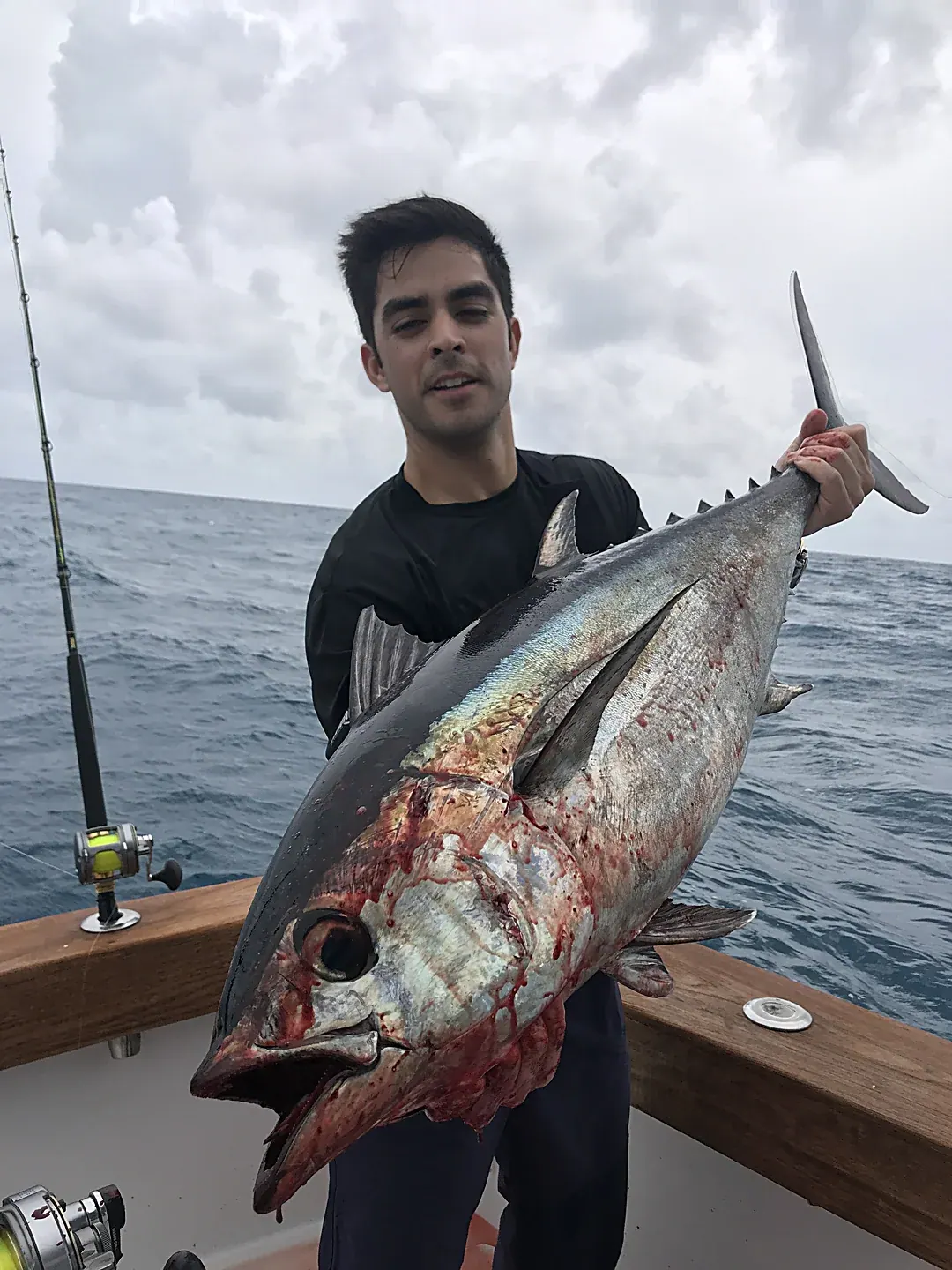 An angler holding a spring blackfin tuna boatside off Miami