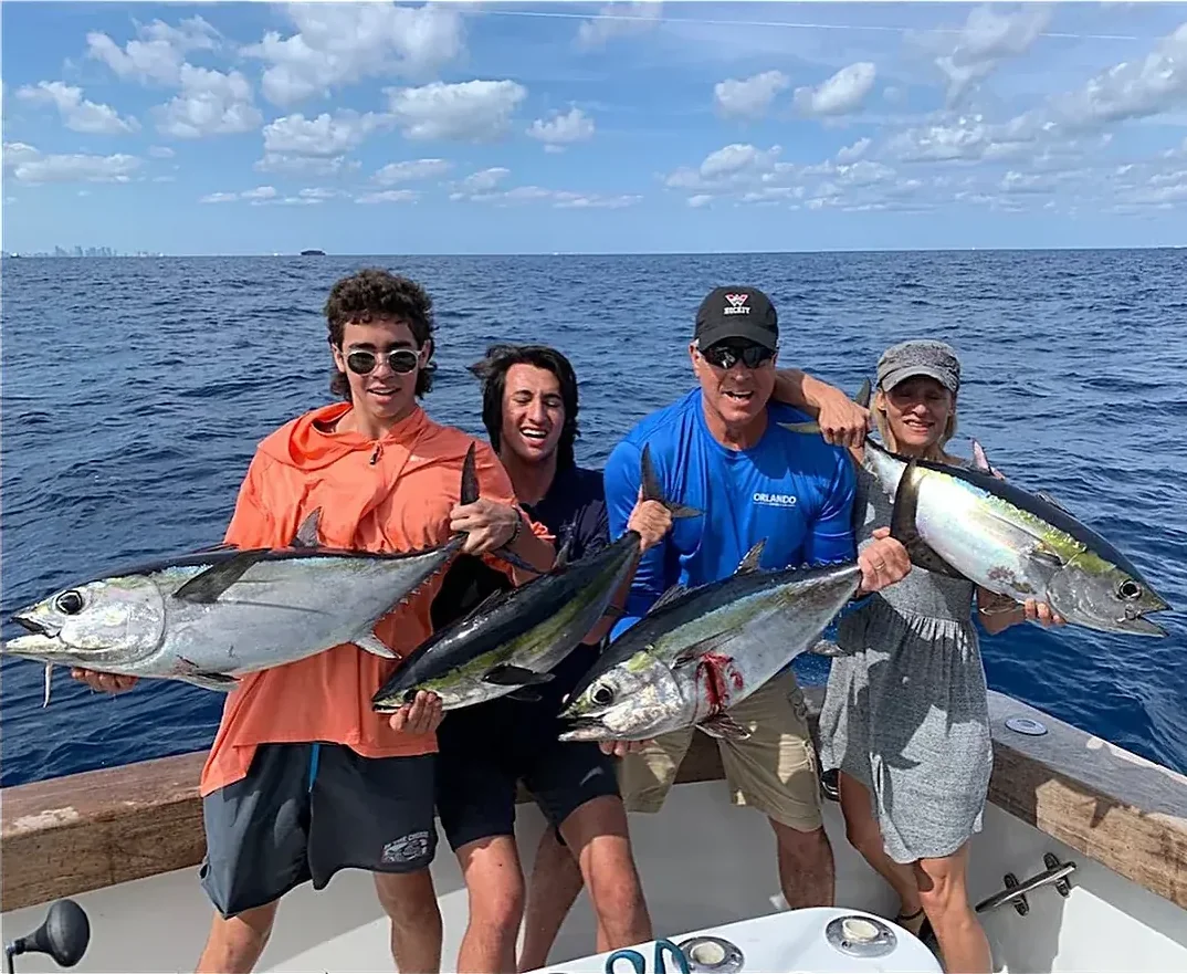Four anglers each holding a blackfin tuna after a multiple hookup off Miami