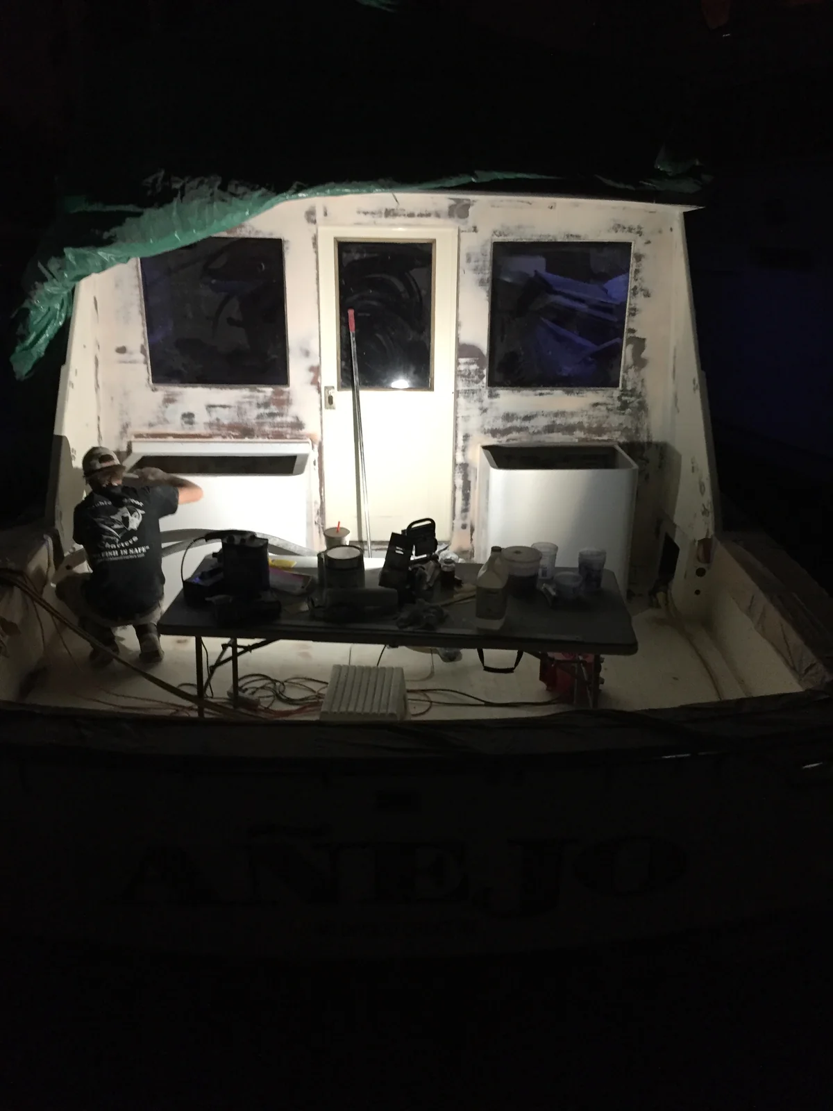 Working on the boat at night under a worklight after a full day of charters