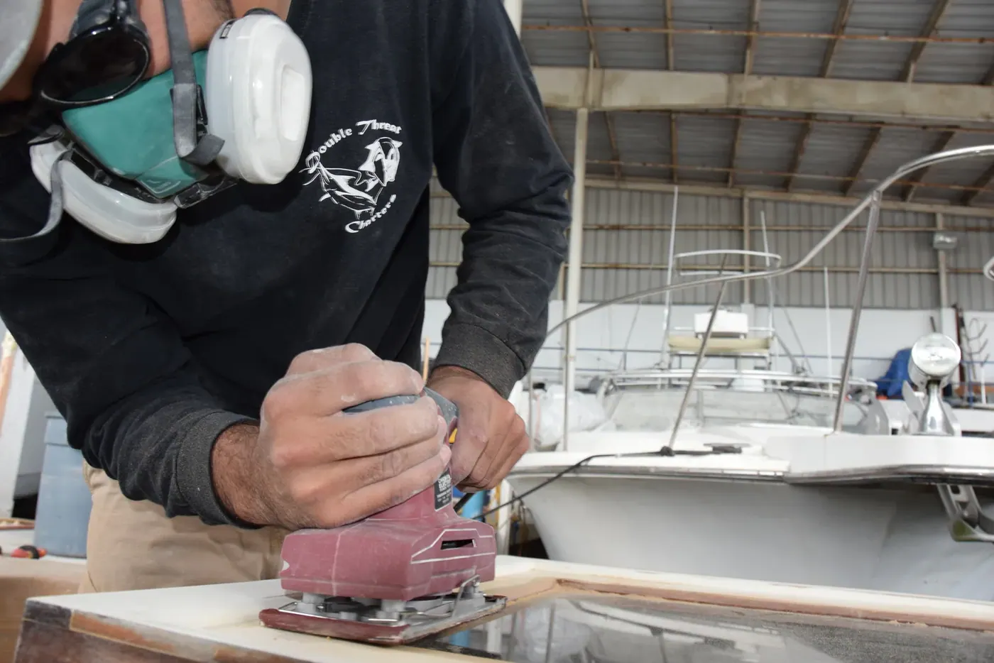 Sanding a teak component in a respirator during the rebuild