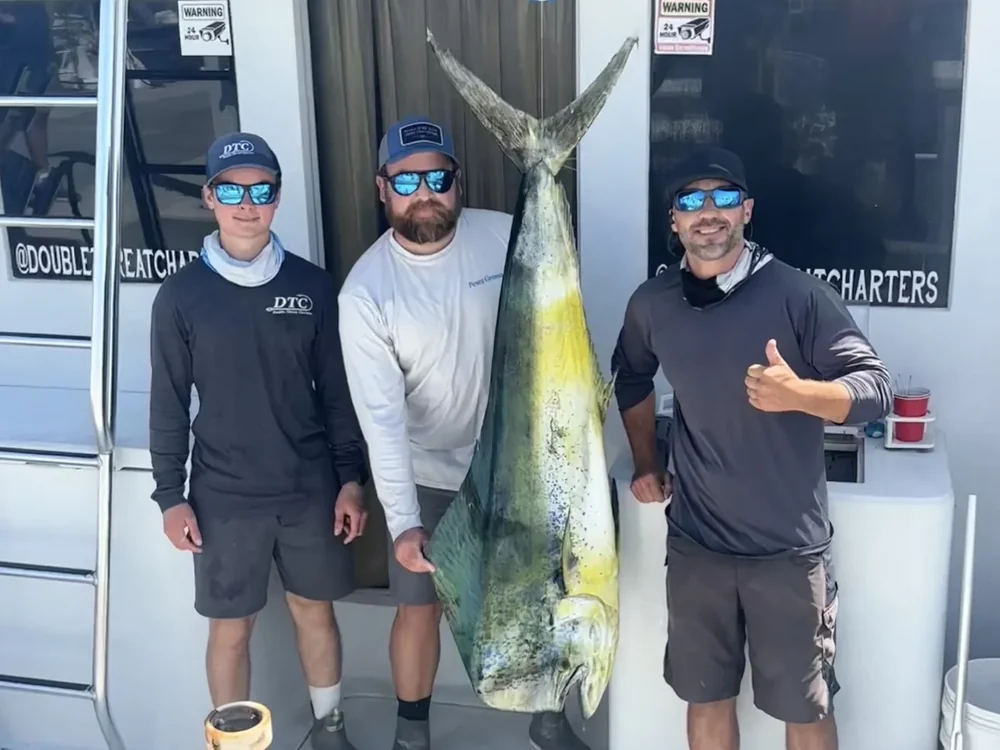 The Double Threat crew at the dock with a bull mahi-mahi