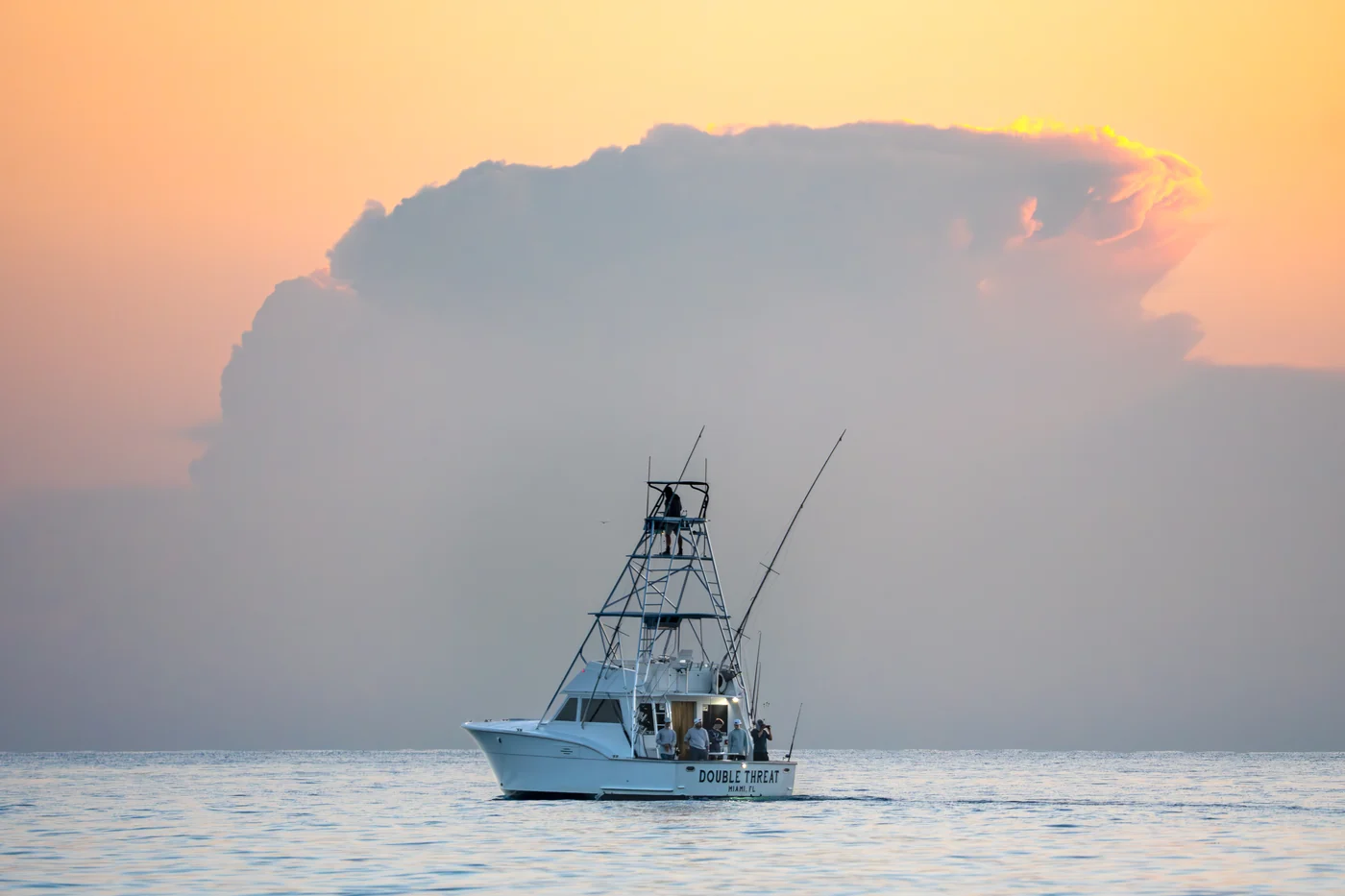 The Double Threat fishing at sunset off Miami beneath a towering cloud
