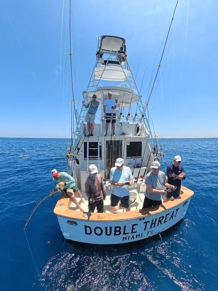 The Double Threat sportfisherman off Miami with the crew fishing the stern