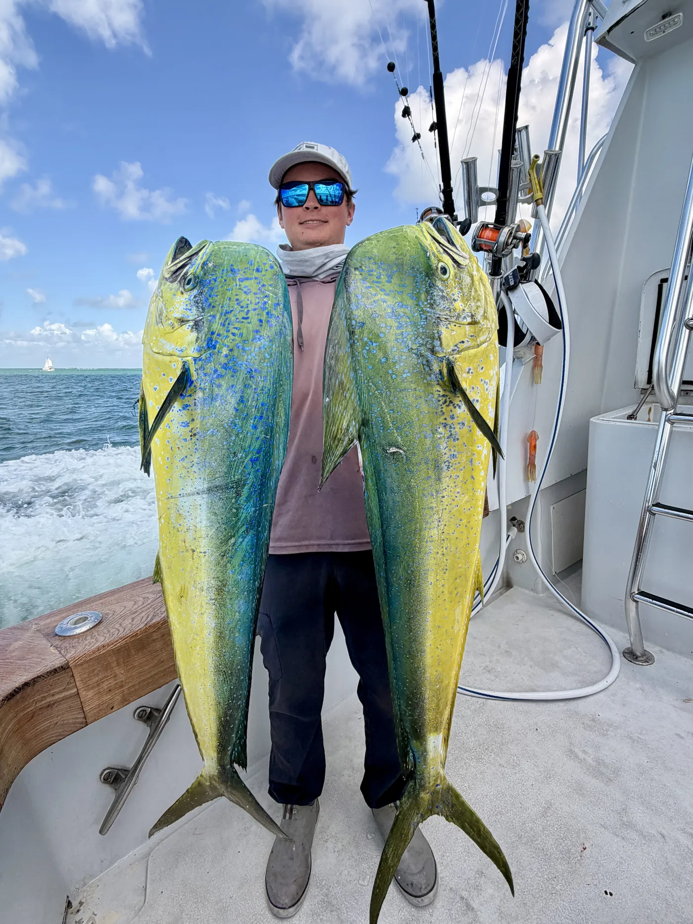 Angler holding a pair of big mahi mahi caught off Miami in June