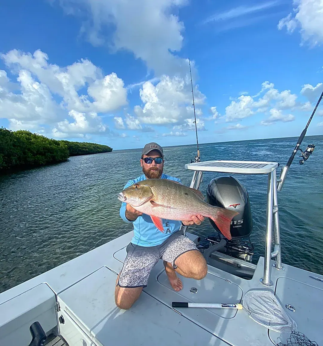 An angler with a mutton snapper caught on the flats off Miami